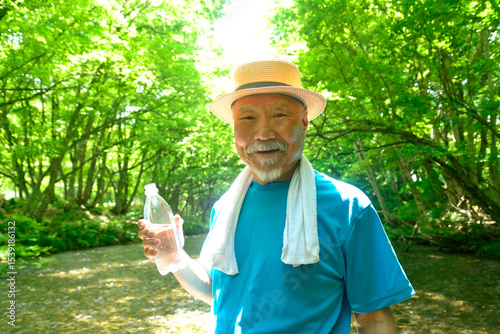 渓流で水分補給をする老人