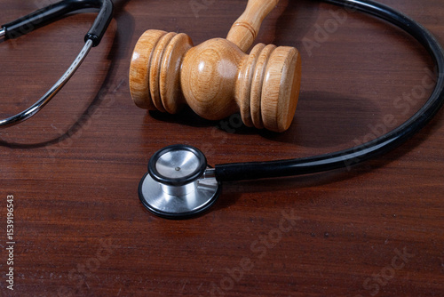A powerful visual of a gavel and stethoscope placed together on a desk symbolizes the legal scrutiny over medical practices.