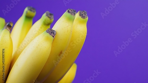 Bunch of ripe bananas against purple