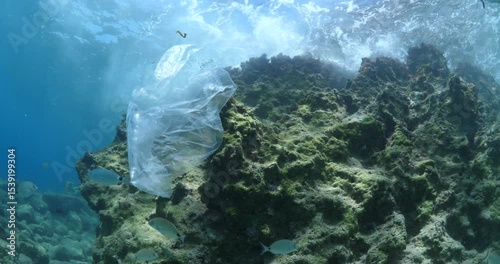 Wallpaper Mural plastic bag underwater , with sun rays waves hit to rocks background ocean pollution Torontodigital.ca