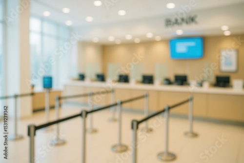 Blurred bank lobby with counter and stanchions creating a queuing area. Financial institution interior with soft focus.