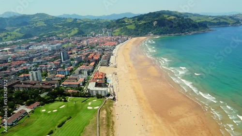 Aerial view of zarautz, a basque country town in gipuzkoa, featuring its beach, buildings, and golf course during a sunny summer day