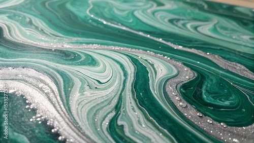 Close up of green and white marbled paint with silver glitter accents and swirls