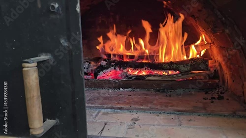 Traditional wood-fired oven with intense flames ready for baking pizzas, pandebonos, and arepas de choclo, rustic cooking with natural firewood heat, glowing embers and authentic culinary ambiance