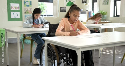 In classroom, diverse multiracial students writing in notebooks, focused on schoolwork