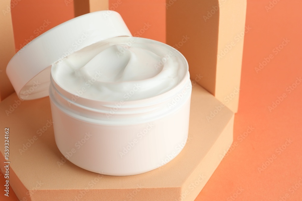 Stylish presentation of moisturizing body cream in jar on orange background, closeup. Space for text Stylish presentation of moisturizing body cream in jar on orange background, closeup. Space for text