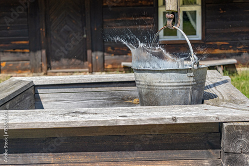 Water splashes from a bucket in a historic well