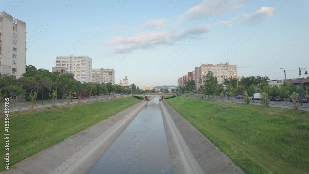 The Bahlui River in Iasi runs through an urban area, framed by grass and distant buildings The Bahlui River in Iasi runs through an urban area, framed by grass and distant buildings