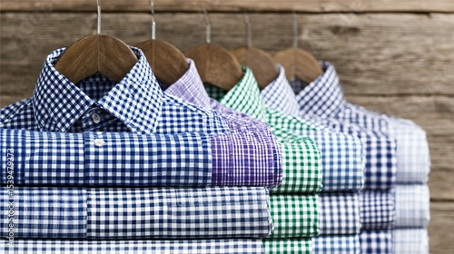 Several folded checked shirts on hangers.