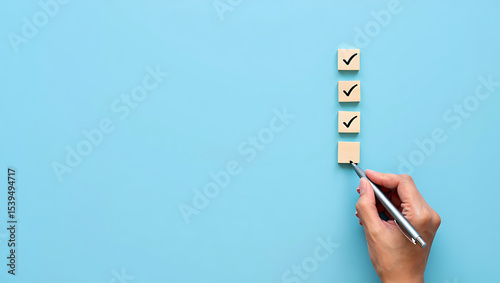 Hand Marking a Completed Checklist with Checkmark Boxes on Wooden Blocks and an Empty Box on a Blue Background, Symbolizing Task Management and Accomplishment