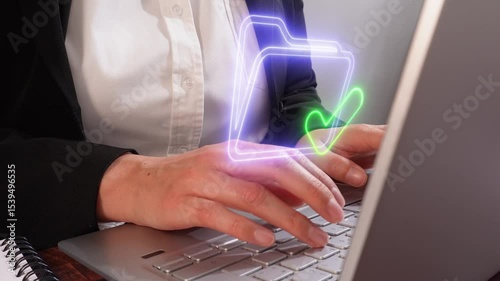 Close-up of a person working on a computer with a hologram of a folder icon with a checkmark, cloud management concept