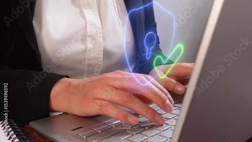 Close-up of a person working on a computer with a hologram of a shield icon with a checkmark, cybersecurity concept