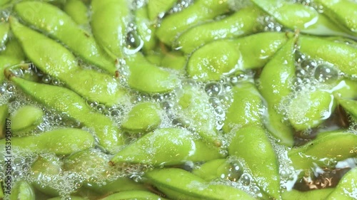 夏野菜の枝豆をお湯で茹でている動画。クローズアップ。左から右へ。