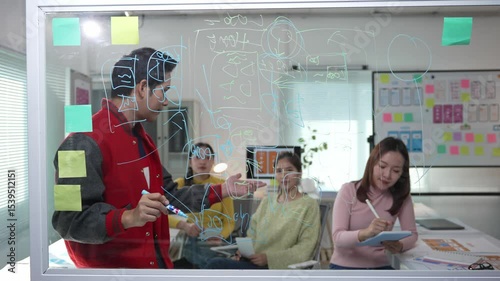 Professional team leader guiding colleagues through strategic project plan, using whiteboard for visual presentation in modern corporate workspace