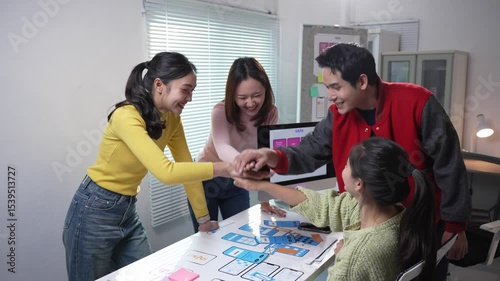 Design team celebrating successful mobile app development, sharing excitement and mutual achievement in modern collaborative workspace with high energy interaction and professional camaraderie