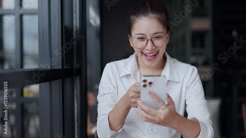 Young Asian businesswoman wearing glasses and white shirt expressing different emotions while using smartphone, from curiosity to surprise and excitement