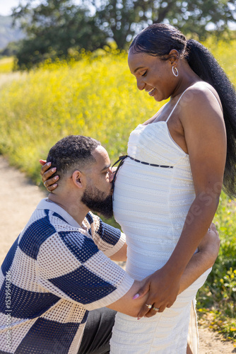 A loving couple expecting a baby enjoys a beautiful summer day in nature, celebrating their love and eagerly anticipating the arrival of their new family member, bringing hope and joy