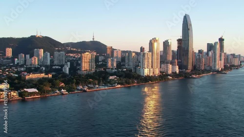 Wallpaper Mural Golden hour cityscape: coastal city skyline at sunset, reflecting on calm waters Torontodigital.ca