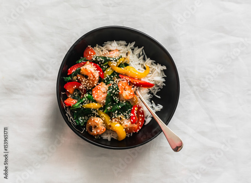 Basmati rice and vegetables, shrimp, spinach stir fry - delicious asian style lunch on a light background, top view