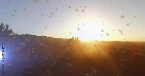 Sun rising above ridge sparking sparkles forming drifting while camera panning showing dawn view