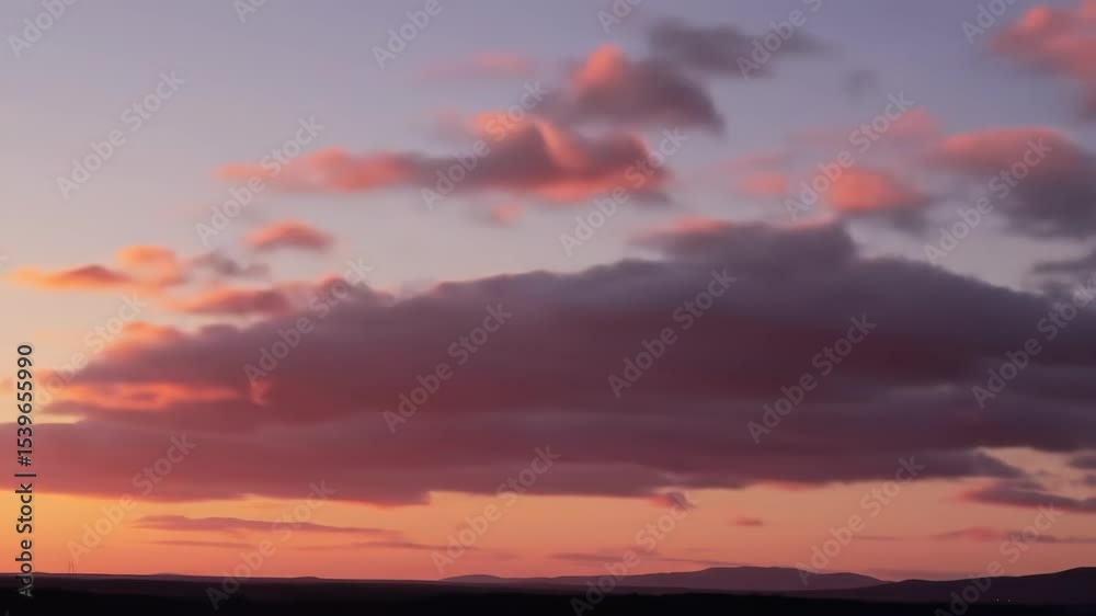 Pink and purple sunset cloudscape over a dark landscape Pink and purple sunset cloudscape over a dark landscape
