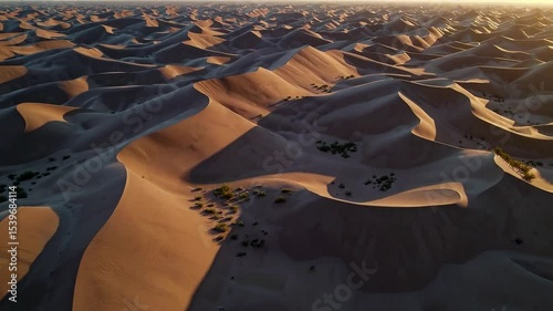 Aerial View of Textured Sand Dunes Under Golden Sunrise Sky in Desert Landscape