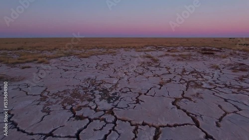 Cracked Earth During Dusk in Expansive Arid Landscape with Gradient Sky Colors