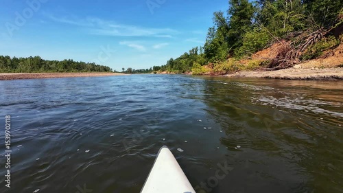Enjoy the tranquility of kayaking on a beautiful river, surrounded by lush greenery and clear blue skies. Ideal for nature lovers and outdoor enthusiasts wanting to connect with nature