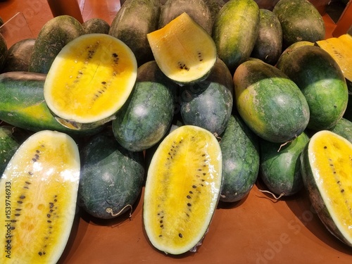 Fresh yellow watermelon on the market stall at supermarket. Slice of tasty yellow watermelon with juicy texture and seeds. Slices of yellow watermelon texture background ideal for fresh produce and he