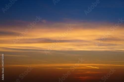 Experience the stunning beauty of a fiery sunset, where vibrant blue, orange, and red hues blend harmoniously above the horizon, creating a peaceful and captivating visual.
