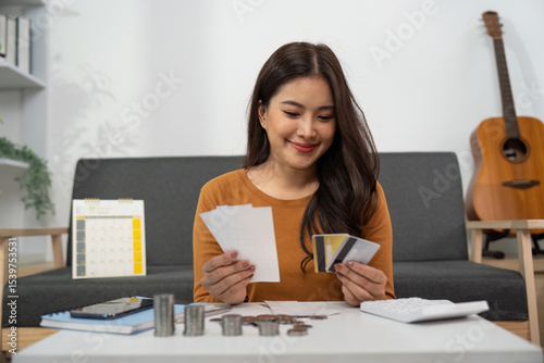 Budgeting and Financial Planning. Woman smiling while reviewing receipts and credit cards.