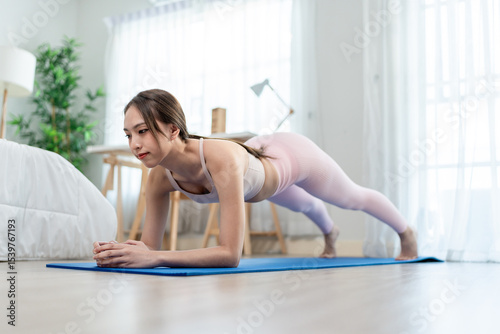 Asian young beautiful sportswoman doing cardio plank workout at home. 
