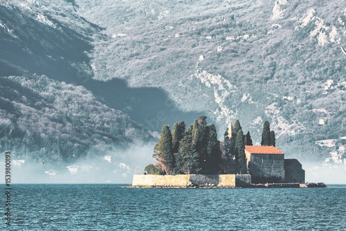 St. George Monastery on islet at sunrise with dramatic mountain shadows in Kotor Bay, Montenegro