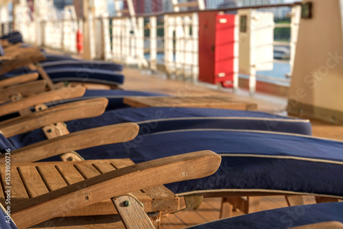 Outdoor promenade boat pool deck onboard modern luxury cruiseship cruise ship ocean liner with sun loungers and deck chairs for guests passengers with ocean views