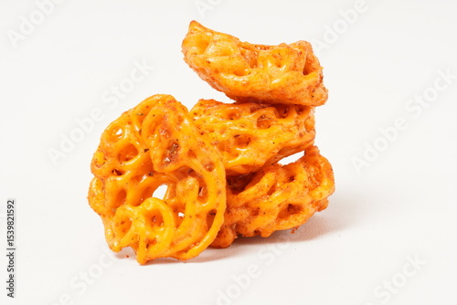 A pile of spicy Indonesian crackers or Kerupuk with spiral twists, coated in red-orange chili powder and rich spices. Bold, flavorful, and appetite-boosting. Photographed against a white background.