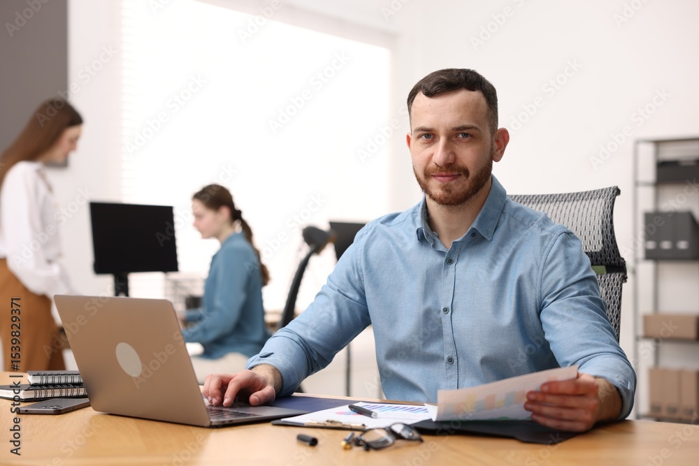 Fototapeta premium Handsome man working at desk in office