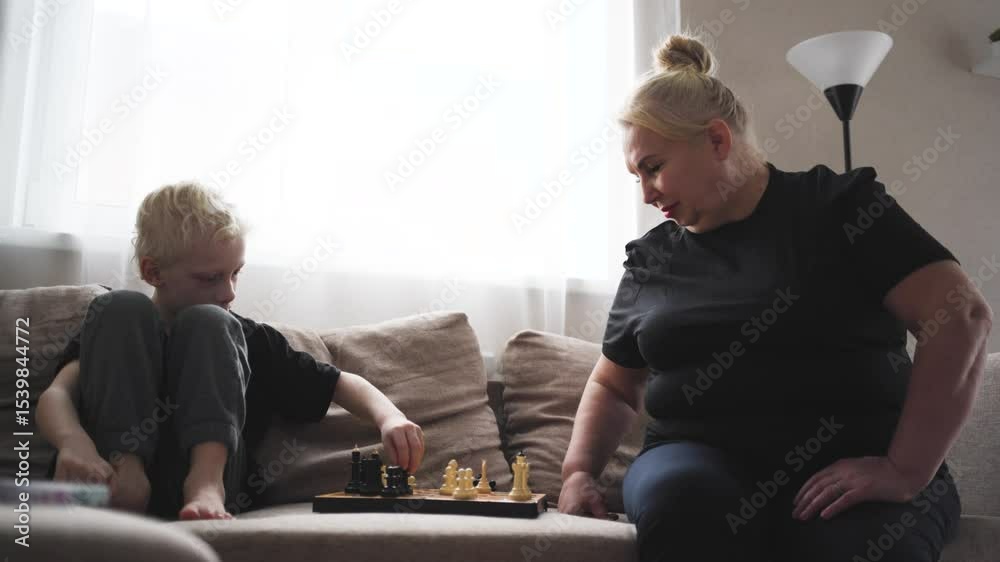 Elderly woman playing chess with her grandson at home. A heartwarming moment of bonding, strategy, and intergenerational connection through a classic intellectual game