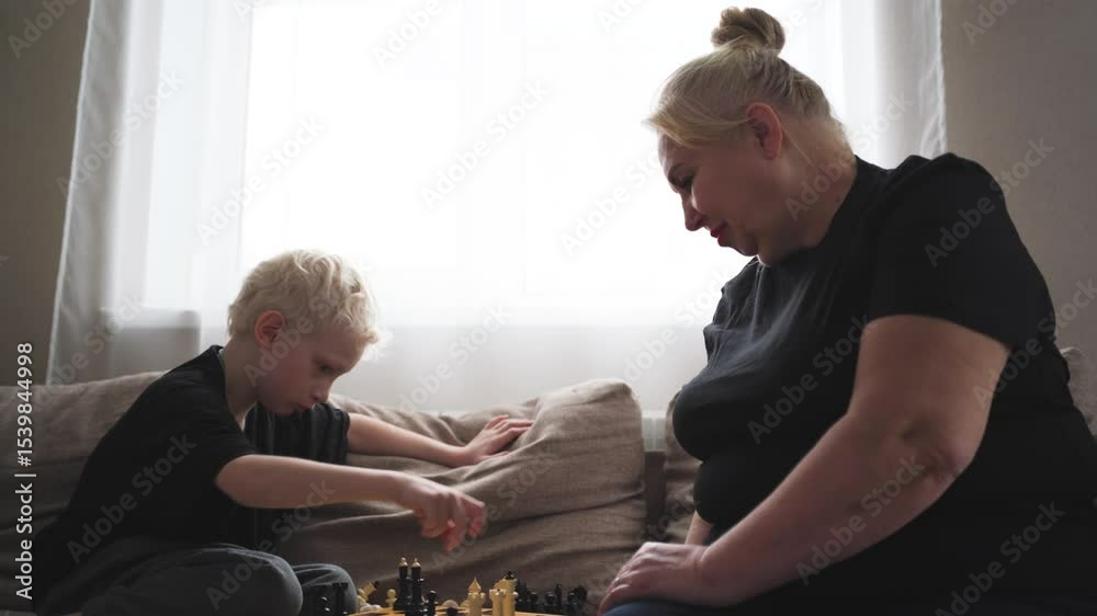 Elderly woman playing chess with her grandson at home. A heartwarming moment of bonding, strategy, and intergenerational connection through a classic intellectual game