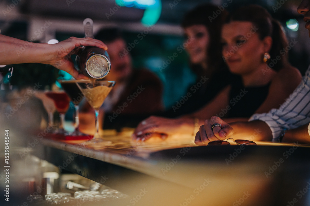 Naklejka premium A bartender skillfully pours cocktails for a group of friends enjoying a night out at a vibrant bar, creating a lively and social atmosphere.
