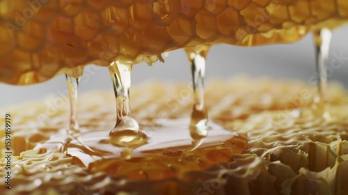 Close-up of golden honey dripping from a honeycomb, showcasing its natural sweetness and texture