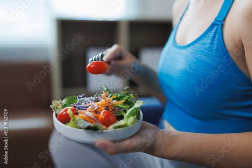Close up of sportswoman eating healthy food in a bowl