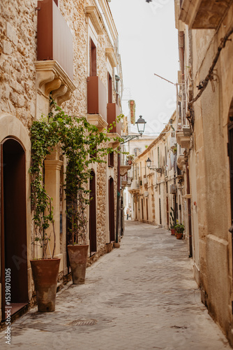 Charming narrow street in Syracuse, Sicily, with baroque stone buildings and Mediterranean character