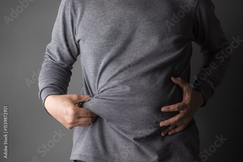 overweight or obese old man shows fat deposits in the abdomen. healthcare, medicine concept.