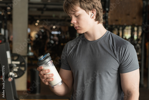 Portrait of sporty caucasian healthy fitness man with protein shake. Athlete and professional trainer with sports nutrition beverage while working out