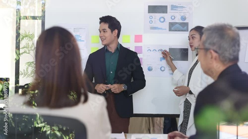 Professional business team analyzing marketing data while presenting strategic insights during collaborative meeting in modern office workspace.