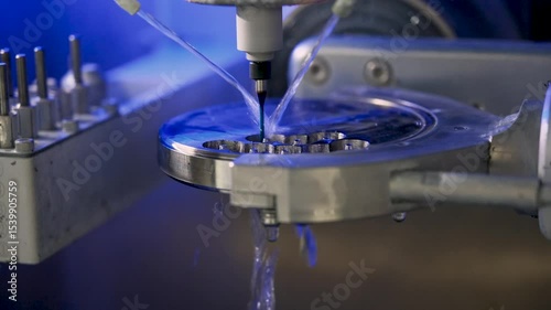 Milling machine for making veneers and crowns. Dental CNC machine processes titanium by rotating, polishing and rinsing with streams of water. Close-up.