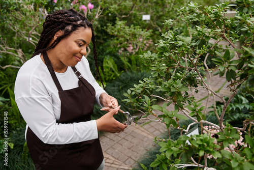 Canvastavla Gardener tending to plants in a vibrant greenhouse filled with lush greenery