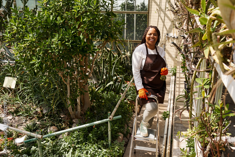 Obraz premium Gardening bliss in a vibrant greenhouse with an inspiring woman tending to her plants