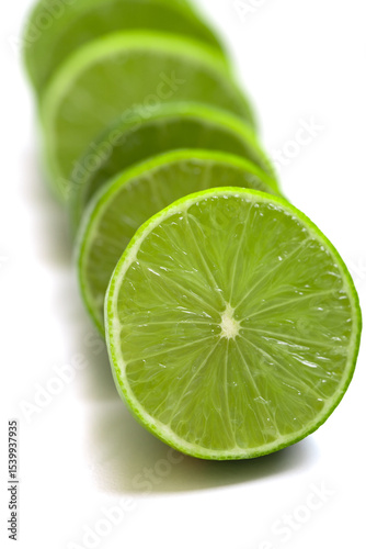 Vibrant green lime halves arranged on a clean white surface. The juicy texture and vivid color evoke a sense of freshness, summer, and natural simplicity. Selective focus.