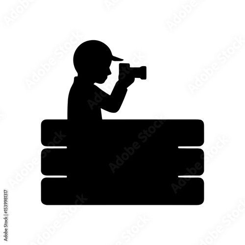 Silhouette of a car and motorsport photographer taking photos behind barrier  